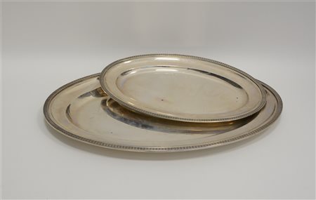 Lotto composto da due vassoi di forma ovale con bordi cesellati a palmette....