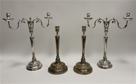 Gruppo di quattro candelieri in metallo argentato due con portacandele...