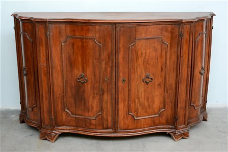 Credenza in noce di forma sagomata con quattro ante decorate con sagomette in r