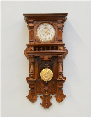 Orologio a muro con cassa in legno di forma architettonica. Quadrante a fascia