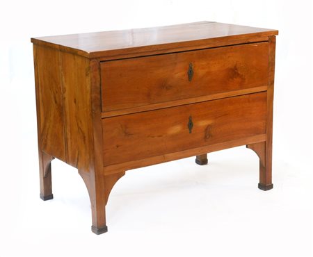 Comoncino lastronato in noce a due cassetti, piedi a pilastro decorati con racc