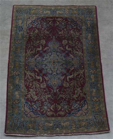 Tappeto Qum, Persia secolo XX.
Decoro a medaglione azzurro su fondo bordeaux co