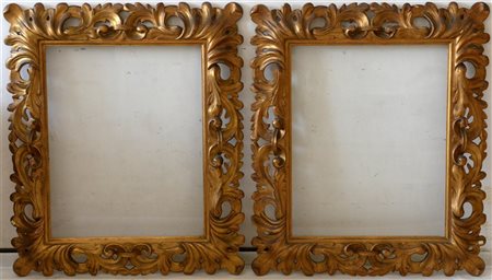 Coppia di cornici in legno intagliato e dorato a motivi fogliacei (luce cm 57x7