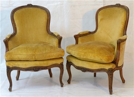 Coppia di poltrone con cimasa intagliata a fiori, braccioli scanalati, gambe mo