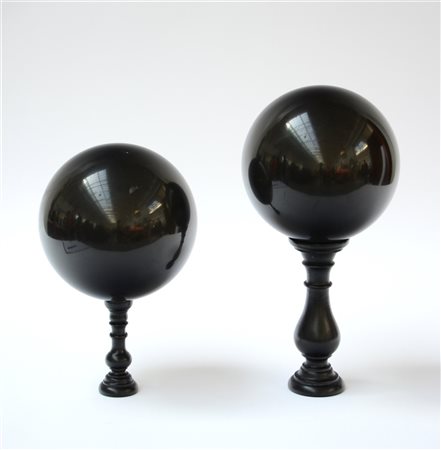 Coppia di elementi decorativi a forma di sfere in marmo nero (difetti)