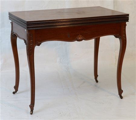 Tavolino in legno con fascia sagomata e gambe di forma mossa munite di rotelle.