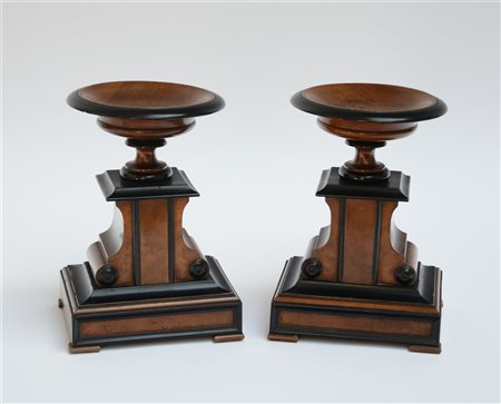 Coppia di elementi decorativi in legno con profili ebanizzati sormontati da cop