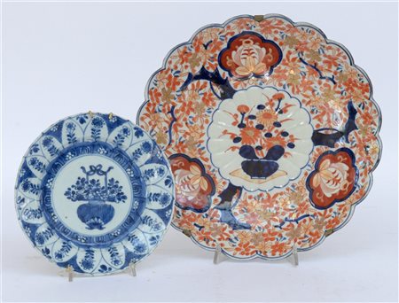 Due piatti in porcellana decorati con ceste di fiori, uno nei toni del bianco e