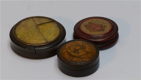Lotto di tre tabacchiere in legno, bachelite e papier-mâché con coperchi decora