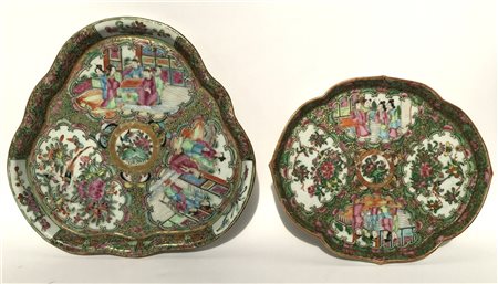 Lotto di due piatti in porcellana con bordi polilobati dipinti con scene e moti