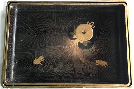 Due vassoi di misure diverse in legno laccato nero, i bordi dorati, decorati co