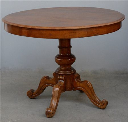 Tavolo tondo con gamba centrale tornita terminante a quattro piedi intagliati e