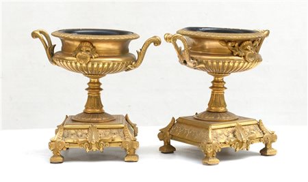 Coppia di alzatine a forma di vasi biansati in metallo dorato e cesellato a vol