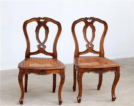 Coppia di sedie da balia in legno intagliato con schienale a giorno e seduta in