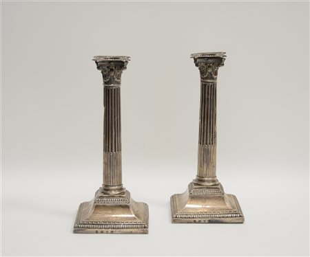 Coppia di candelieri in argento a forma di colonne scanalate con capitelli "Cor