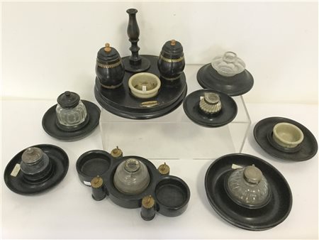 Gruppo di otto calamai in legno ebanizzato di forma circolare con contenitori i