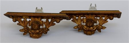Coppia di mensoline in legno laccato con fregi dorati a testa di cherubini alat