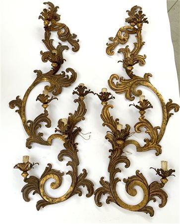 Coppia di grandi appliques a sei fiamme in metallo dorato decorate a volute e m