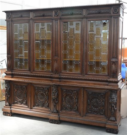 Libreria a due corpi di gusto neorinascimentale con vetri legati a piombo sormo