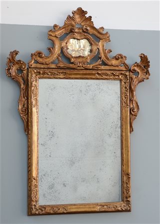 Specchio in legno intagliato e dorato con cimasa scolpita e traforata (cm 110x7