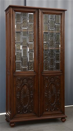 Libreria a due ante con pannelli in legno intagliato e vetri legati a piombo (c