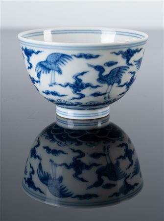 Arte Cinese  A blue and white porcelain cup painted with cranes among clouds and bearing a six character Chenghua mark at the base China, 20th century .