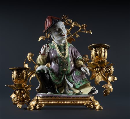 Arte Cinese  A famille verte porcelain figure of a dignitary within French gilded foliated XIX century mount China, Qing dynasty, Kangxi period (1662-1722).
