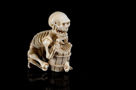ARTE GIAPPONESE  An ivory netsuke depicting a skeleton on a barrel. Signed at the base.Japan, 19th century .
