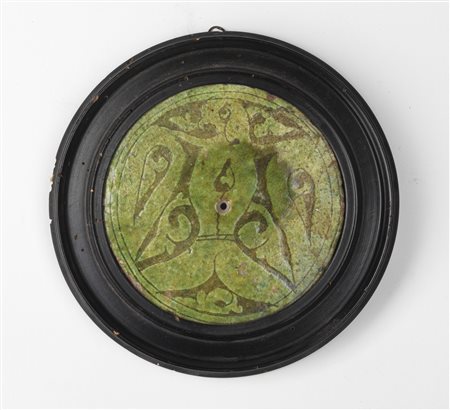 Arte Islamica  A Garrus round tile with carved through decoration with birdIran, 12th-13th century .