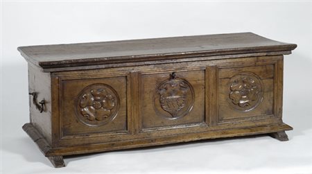 Cassa in noce, fronte percorso da formelle con intagli, maniglie laterali...