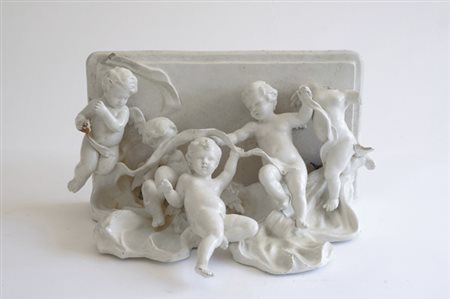 Mensola in porcellana bianca con putti festanti, cm. 36,5x42x24. € 200/400