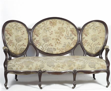 Divano in noce, schienale tripartito, montanti e braccioli sagomati,...