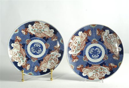 Coppia piatti Imari in porcellana a fondo blu, con decori a paesaggi entro...