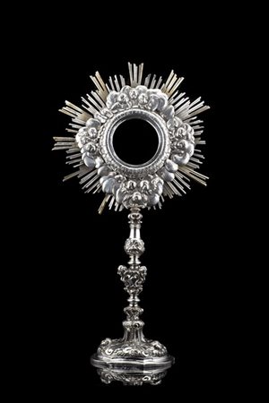 Ostensorio in argento con fusto a balaustro sbalzato a volute e decorato a test