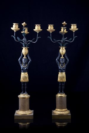Coppia di candelieri a tre fiamme in bronzo brunito e dorato, fusto in forma di