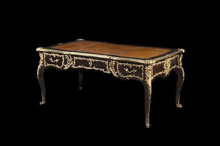 Scrivania da centro di forma mossa lastronata in ebano e palissandro. Fronte a