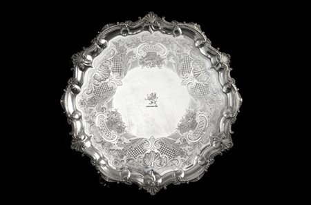 Salver in argento inciso a volute fogliate, fiori e cesti di frutta, bordo sago