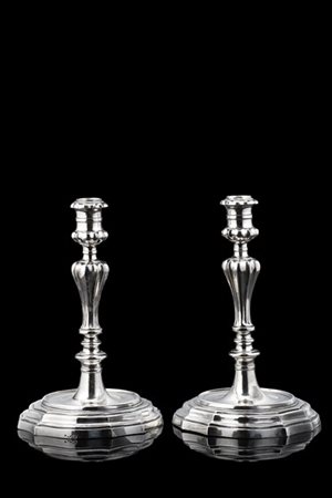 Coppia di candelieri in argento con fusto tornito e scanalato poggiante su base