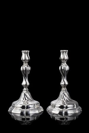 Coppia di candelieri in argento con fusto a torchon poggiante su base sagomata.