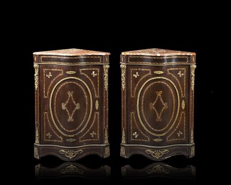 Coppia di angoliere lastronate in mogano con fronte ad un'anta di forma mossa,