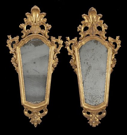 Coppia di specchiere in legno dorato con cimasa intagliata e traforata a volute
