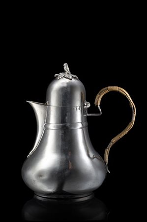 Caffettiera in argento a corpo piriforme. Coperchio a cupola cimato da foglia d