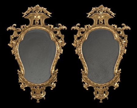 Coppia di specchiere in legno intagliato e dorato con cimasa e fregi traforati