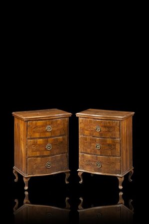 Coppia di comodini in noce con fronte mosso a tre cassetti filettati e pannella