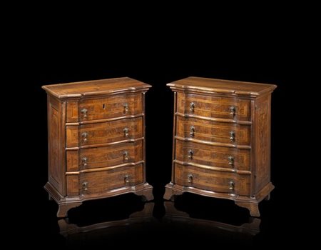 Coppia di comodini di forma mossa lastronati in noce e filettati, uno a quattro