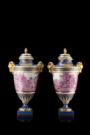 Manifattura francese, secolo XIX. Coppia di vasi biansati in porcellana a fondo