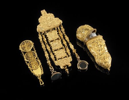 Nécessaire in metallo dorato e sbalzato a figure e fiori, unito a due chatelain