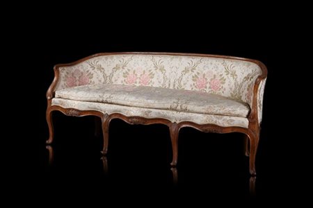 Divanetto in noce a quattro posti con braccioli sagomati e terminanti a ricciol