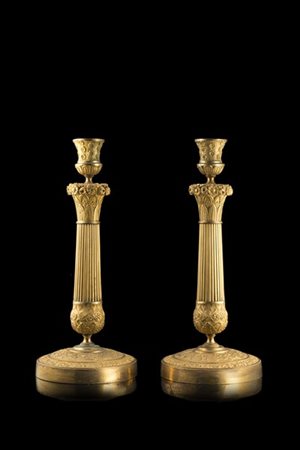 Coppia di candelieri in bronzo dorato con colonna scanalata decorata a fiori e