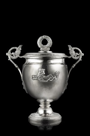 Coppa biansata con coperchio in argento decorata a cesellature. Corpo ad animal